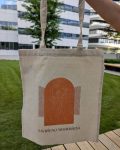 Ceger sa natpisom Savršeno nesavršena, pozadina trava i poslovna zgrada