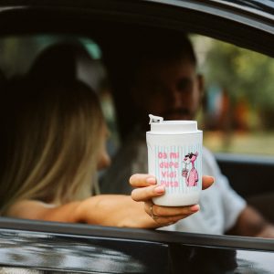 Parr u autu, gde devojka drzi ruku na prozoru, a u ruci termo solju